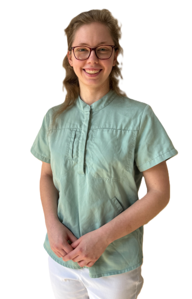 Junge Frau mit Brille in einem mintgrünen Oberteil, lächelt und steht mit gefalteten Händen.